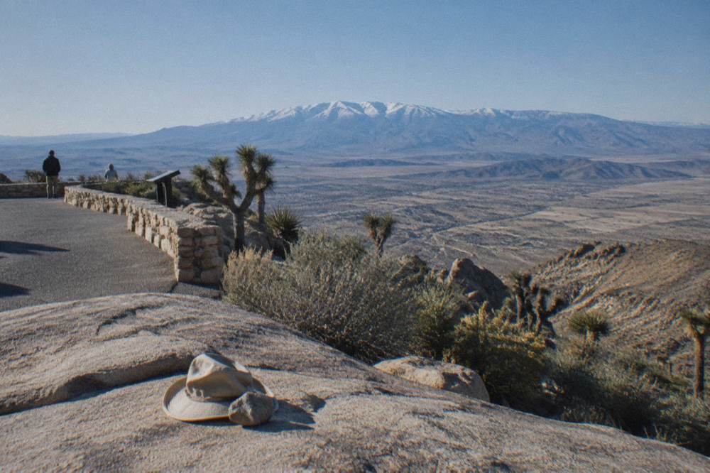 A scenic overlook above a wide desert valley with distant mountains on the horizon