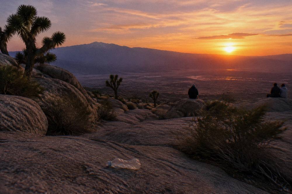 Sunset colors over desert plain and mountains seen from a rocky overlook