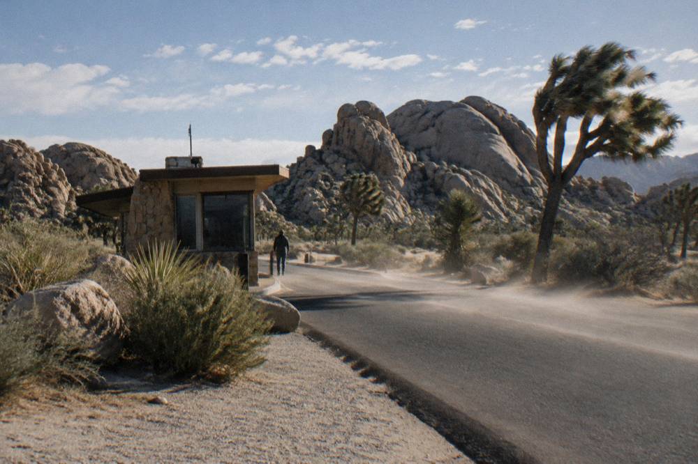 Entrance station booth at the edge of the desert with a line of rock formations behind
