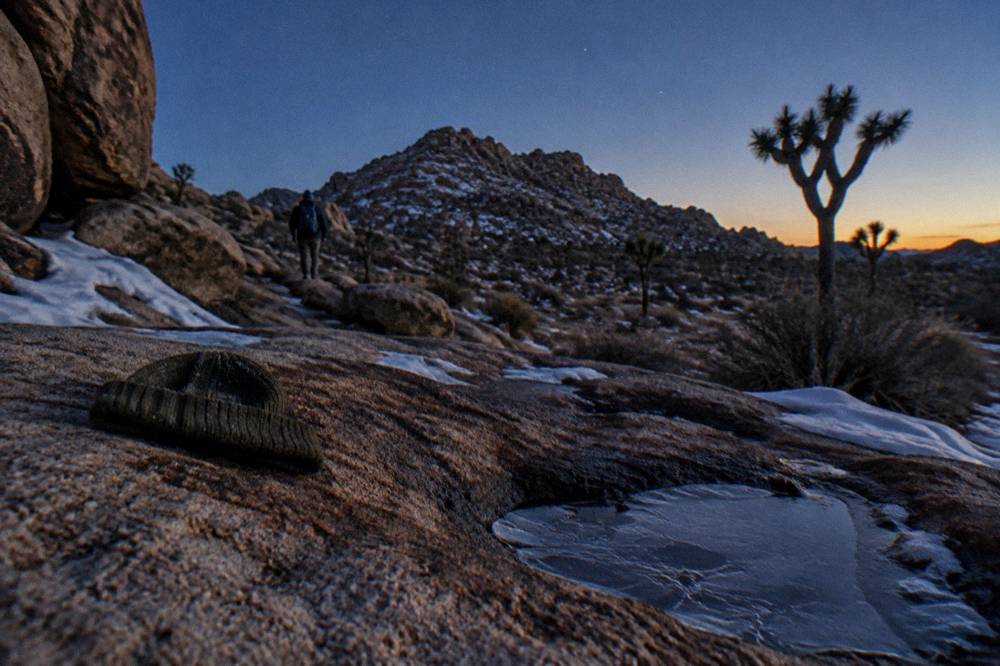Snow-dusted boulders under a clear starry sky at dusk