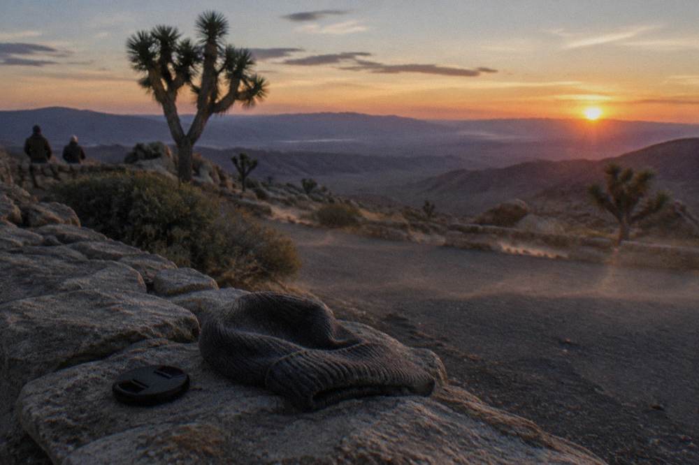 Sunset light over a desert valley with darkening ridgelines on the horizon
